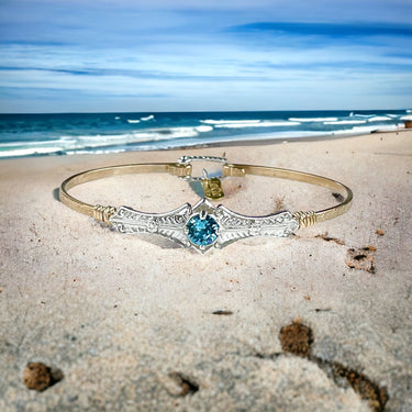 Silver bracelet with a turquoise gemstone on a beach background