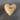 Wooden heart-shaped object with 'love' engraving on a gray surface