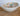 White bowl with colorful speckles on a wooden surface