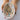 Hand holding a white ceramic dish with colorful speckled pattern on a white background
