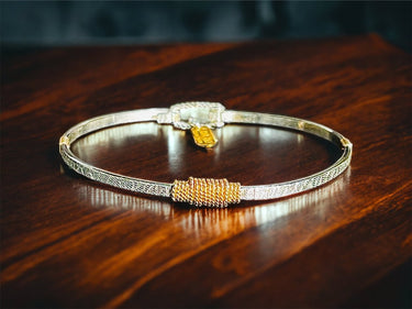 Gold and silver bracelet on a wooden surface