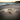 Gold bracelet with a blue Crystal on a sandy beach at sunset