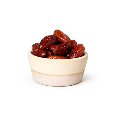 Small beige bowl filled with dates on a white background