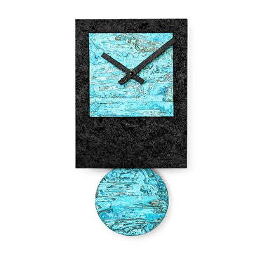 Black Tie pendulum wall clock styled in a modern room, minimalist black wood and verdigris copper design.
