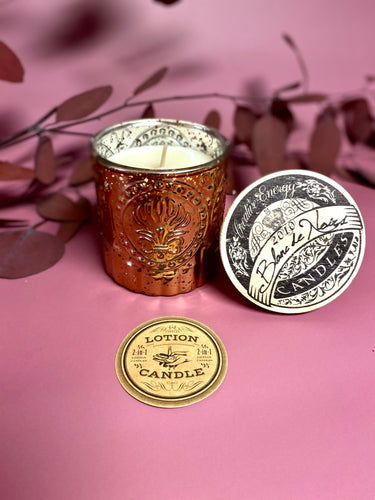 Blanc de Noirs Soy Candle in Copper Mercury Glass Jar with a candle inside, surrounded by decorative elements on a pink background