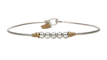 Silver bracelet with gold accents on a white background