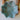 Turquoise ceramic bowl with intricate pattern held by a person