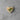 Wooden heart-shaped pin with a green ribbon on a concrete surface