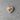Heart-shaped wooden pin with a purple ribbon on a gray concrete surface