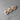 Three wooden heart-shaped pins with purple ribbons on a gray surface