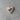 Heart-shaped wooden pin with a blue ribbon symbol on a gray concrete surface