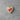 Heart-shaped wooden pin with a pink ribbon on a gray concrete surface