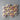 Wooden hearts with purple awareness ribbons arranged in a circular pattern on a gray surface.