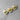 Three wooden heart-shaped pins with green ribbons on a gray surface