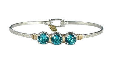 Silver bracelet with three turquoise stones on a white background