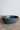 Dark blue ceramic bowl on a wooden surface with a light gray background