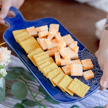 Blue Cheese Borad with crackers and cantaloupe on a tablecloth.