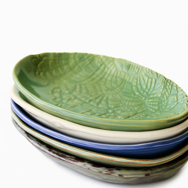 Stack of ceramic plates with textured surface on a white background