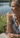 Woman wearing a bracelet by a lake with flowers in the background