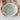 Person holding a ceramic bowl with a light blue interior on a white background