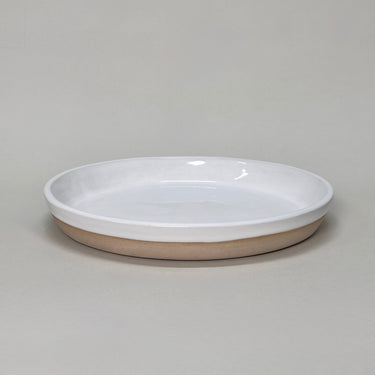 Ceramic dish with white top and beige bottom on a gray background