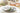 Decorative plate with floral design on a table setting with glasses and cutlery.