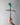 Hand holding a metal dragonfly Vine cross against a plain background