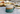 Speckled ceramic mug with two-tone design on a picnic blanket with food in the background