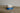 earthenware mug with blue base and speckled white body on a wooden surface