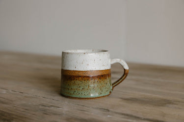 earthenware mug with two-tone design on a wooden surface