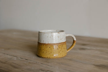 earthenware Mug with speckled design on a wooden surface