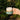 Hand holding a earthenware ceramic mug with a natural finish against a green outdoor background