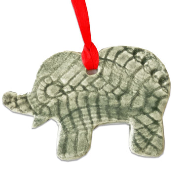 Decorative elephant ornament with a textured surface and red ribbon on a white background
