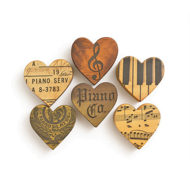 Set of wooden heart-shaped coasters with musical designs on a white background