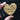 Heart-shaped wooden tag with text held by a hand against a dark background
