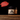 Jar of Johnny Licks pomade with directions on a wooden surface and black background