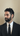Man wearing a black suit and tie against a beige background