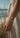 Hand wearing a silver bracelet with a blurred beach background