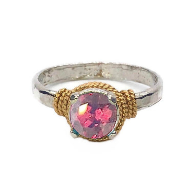 Ring with pink gemstone and gold and silver band on white background