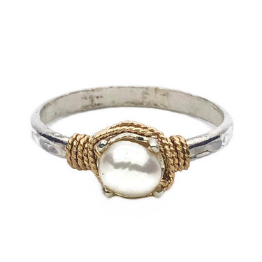 Silver ring with a gold rope design and pearl center on a white background