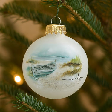 Decorative Christmas ornament with a painted boat on a white background, hanging on a tree.