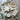 Ceramic tray with star-shaped bowl, candle, and soap on a wooden surface with greenery.