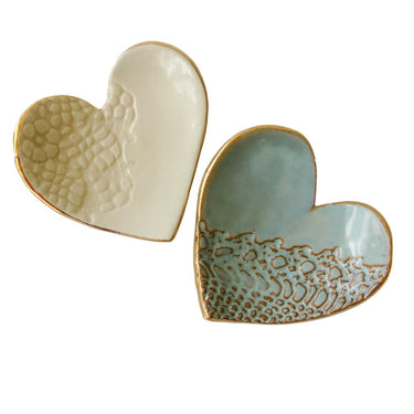 Two ceramic heart-shaped dishes with textured surfaces on a white background