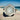 Silver ring with a hexagonal gemstone on a sandy beach