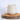White textured mug on a wooden coaster with a white background