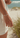 Hand wearing a bracelet on a beach with blurred background