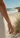 Hand wearing a silver bracelet on a sandy beach with ocean view