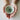 Two hands holding a small ceramic bowl with a textured interior on a plain background