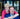 Two people posing together in a room with a blurred background