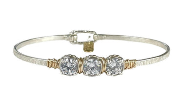 Silver bracelet with three clear gemstones on a white background